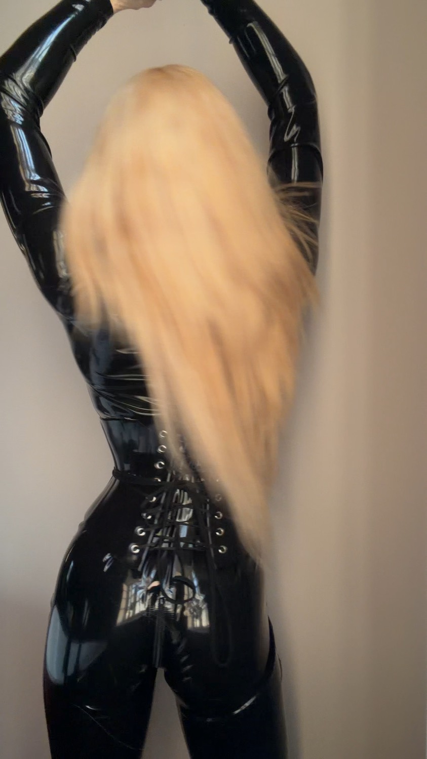 Aria from behind in a latex catsuit.